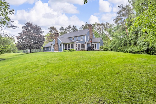 5340 Squires Manor Rd, Jackson, MI 49201 - view of front facade featuring a chimney, a front yard, and a sunroom