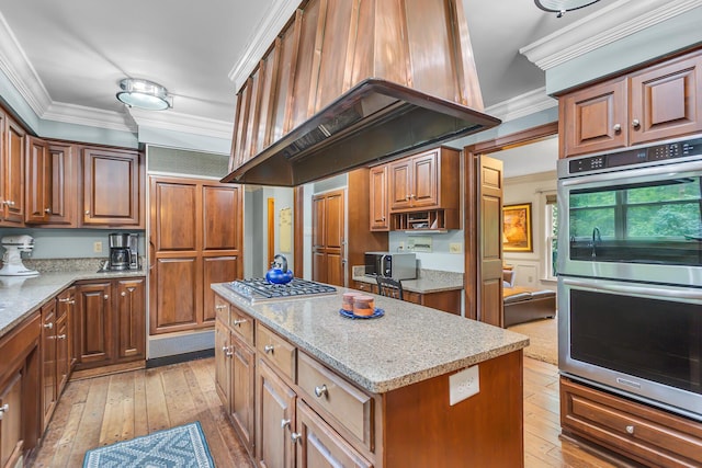 5340 Squires Manor Rd, Jackson, MI 49201 - kitchen with appliances with stainless steel finishes, extractor fan, crown molding, a center island, and light wood-style flooring