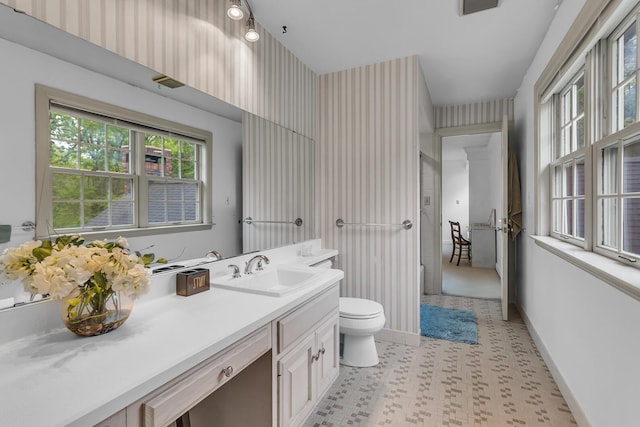 5340 Squires Manor Rd, Jackson, MI 49201 - bathroom with toilet, baseboards, vanity, tile patterned floors, and wallpapered walls