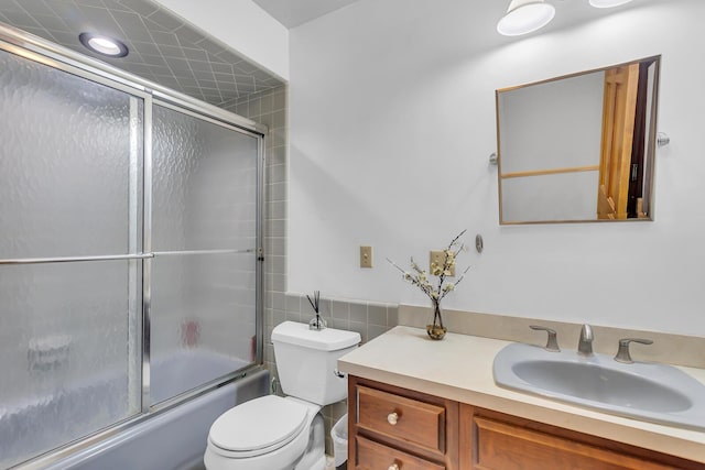 5340 Squires Manor Rd, Jackson, MI 49201 - full bath featuring toilet, vanity, bath / shower combo with glass door, and tile walls