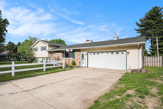 823 W Park Dr, Niles, MI 49120 - tri-level home featuring concrete driveway, a garage, a chimney, and brick siding