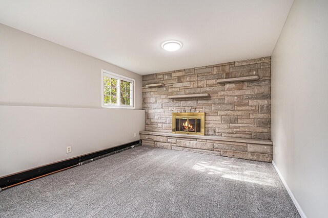 823 W Park Dr, Niles, MI 49120 - unfurnished living room featuring carpet flooring, a stone fireplace, and baseboards