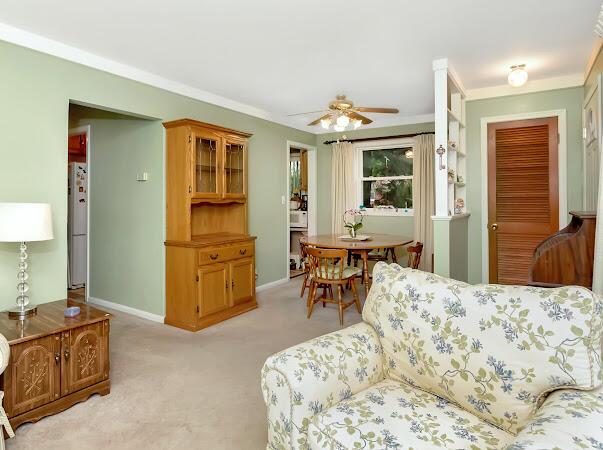 23165 Church St, Oak Park, MI 48237 - living room with light carpet, ceiling fan, baseboards, and ornamental molding