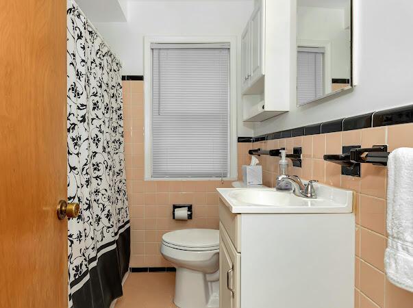 23165 Church St, Oak Park, MI 48237 - bathroom with tile walls, vanity, toilet, a shower with curtain, and wainscoting