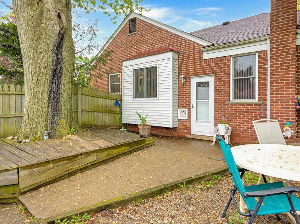 23165 Church St, Oak Park, MI 48237 - rear view of house with brick siding, a shingled roof, a chimney, and a deck