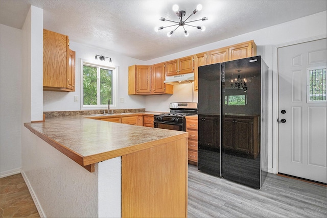 70025 Union Rd, Union, MI 49130 - kitchen with black appliances, a chandelier, under cabinet range hood, a peninsula, and a sink