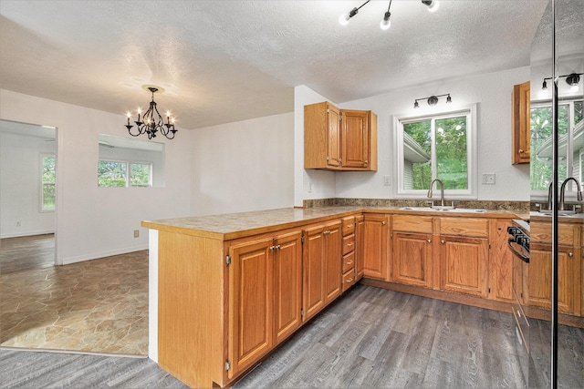 70025 Union Rd, Union, MI 49130 - kitchen with a sink, a chandelier, a peninsula, a textured ceiling, and brown cabinets
