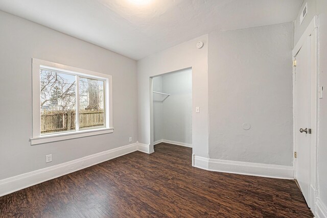 407 11th St NW Unit 409, Grand Rapids, MI 49504 - unfurnished bedroom with dark wood-style floors, baseboards, and a closet