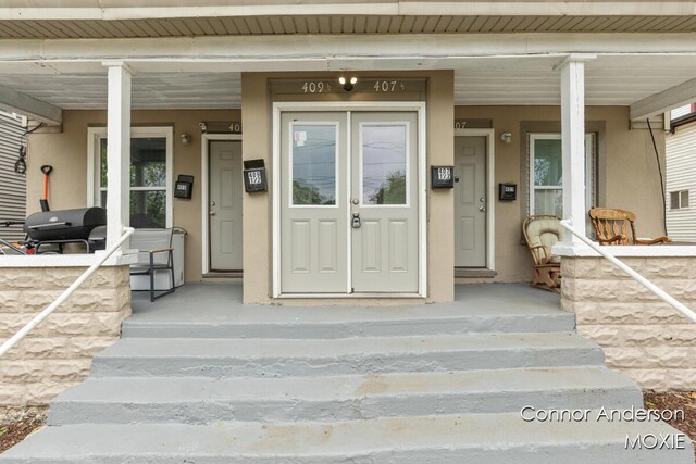 407 11th St NW Unit 409, Grand Rapids, MI 49504 - property entrance featuring a porch and stucco siding