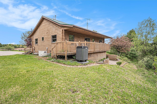 884 N Gavord Rd, Sterling, MI 48659 - view of side of home featuring cooling unit, a yard, a wooden deck, and log siding