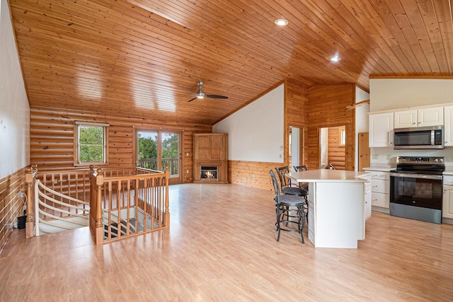 884 N Gavord Rd, Sterling, MI 48659 - kitchen with appliances with stainless steel finishes, wooden ceiling, high vaulted ceiling, rustic walls, and white cabinets