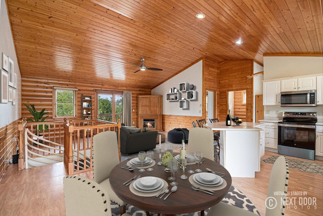 884 N Gavord Rd, Sterling, MI 48659 - dining space with wood ceiling, light wood finished floors, rustic walls, high vaulted ceiling, and a glass covered fireplace