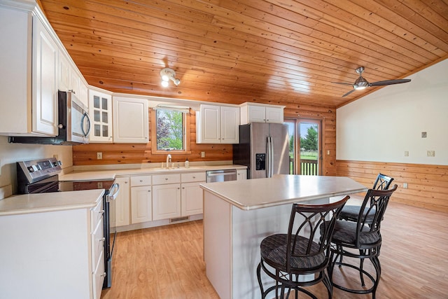 884 N Gavord Rd, Sterling, MI 48659 - kitchen featuring appliances with stainless steel finishes, wooden ceiling, plenty of natural light, a wainscoted wall, and a breakfast bar area