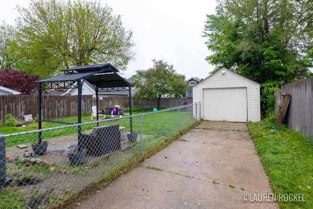 839 Joslin St SE, Grand Rapids, MI 49507 - view of yard with a gazebo, concrete driveway, a garage, and an outbuilding