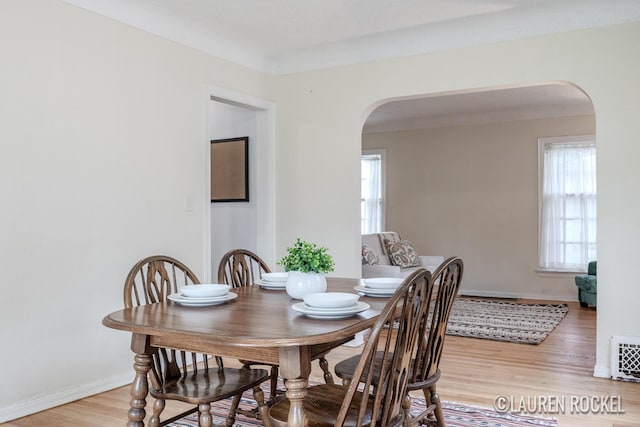 839 Joslin St SE, Grand Rapids, MI 49507 - dining space with arched walkways, light wood-style flooring, healthy amount of natural light, and baseboards