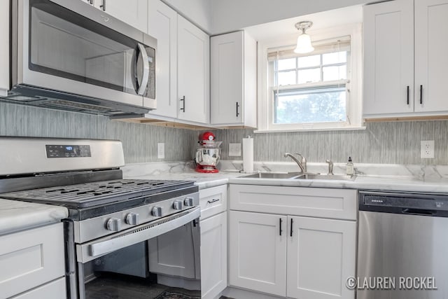 839 Joslin St SE, Grand Rapids, MI 49507 - kitchen featuring stainless steel appliances, a sink, white cabinets, and backsplash
