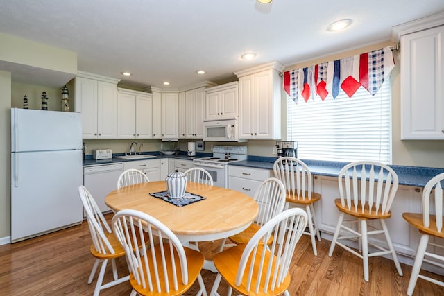 5632 N Watervliet Rd Unit 22, Watervliet, MI 49098 - kitchen featuring white appliances, a sink, dark countertops, light wood finished floors, and white cabinets