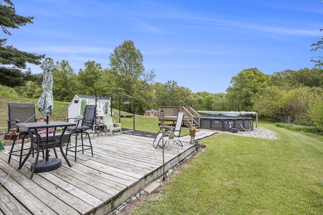 11713 Rountree Rd, Hanover, MI 49241 - wooden deck featuring a yard, a covered pool, outdoor dining space, and view of wooded area