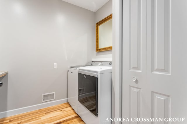 17946 Robbins Rd, Grand Haven, MI 49417 - laundry area featuring washing machine and dryer, baseboards, and light wood finished floors