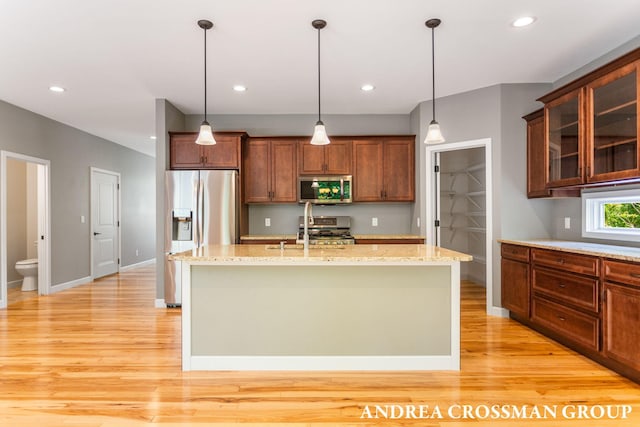 17946 Robbins Rd, Grand Haven, MI 49417 - kitchen with stainless steel appliances, light wood-style flooring, decorative light fixtures, an island with sink, and recessed lighting