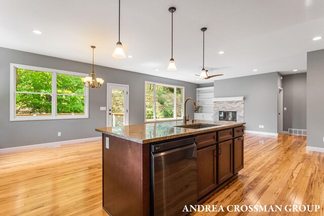 17946 Robbins Rd, Grand Haven, MI 49417 - kitchen featuring dishwasher, a sink, a stone fireplace, light wood-style flooring, and recessed lighting