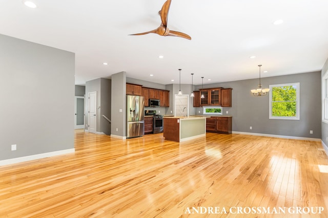 17946 Robbins Rd, Grand Haven, MI 49417 - kitchen featuring stainless steel appliances, open floor plan, a sink, a chandelier, and light wood-style floors