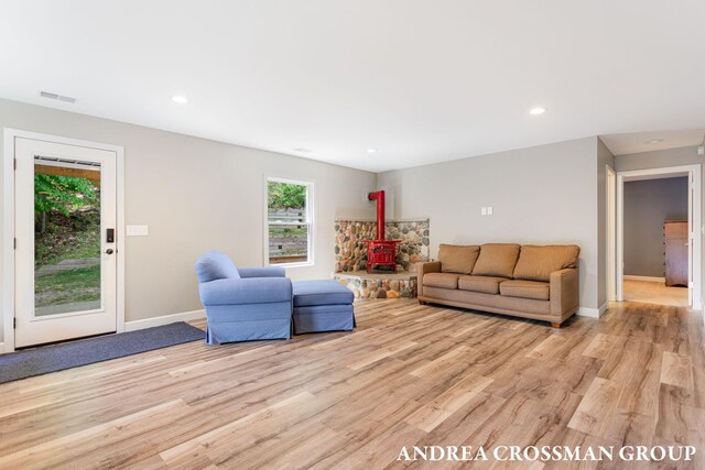17946 Robbins Rd, Grand Haven, MI 49417 - living room with light wood finished floors, a wood stove, baseboards, and recessed lighting