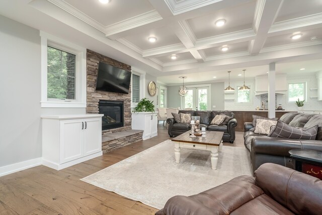 6606 Spaniel Dr, Kalamazoo, MI 49009 - living room featuring crown molding, light wood-type flooring, beam ceiling, a fireplace, and coffered ceiling