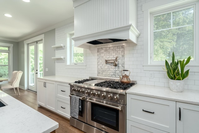 6606 Spaniel Dr, Kalamazoo, MI 49009 - kitchen featuring range with two ovens, premium range hood, crown molding, white cabinetry, and tasteful backsplash