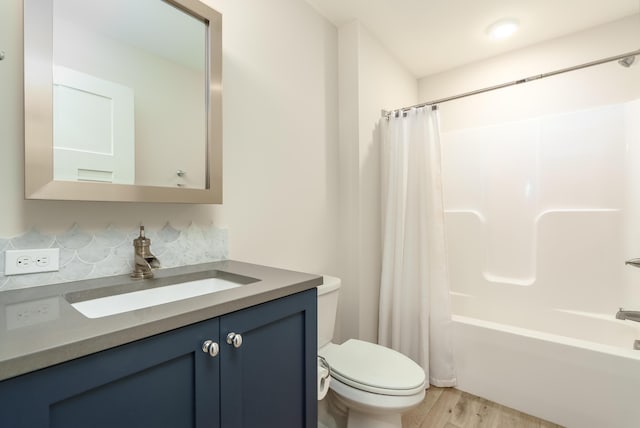 6606 Spaniel Dr, Kalamazoo, MI 49009 - bathroom with toilet, vanity, shower / tub combo with curtain, wood finished floors, and backsplash