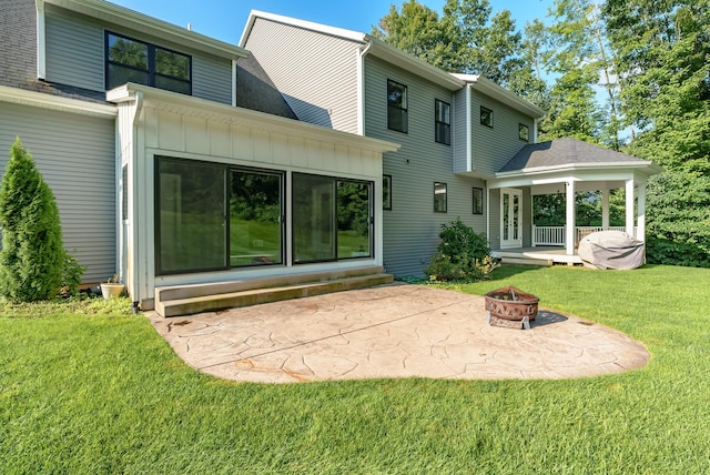 6606 Spaniel Dr, Kalamazoo, MI 49009 - rear view of property with an outdoor fire pit, a patio, a lawn, board and batten siding, and entry steps
