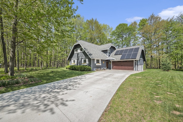 9787 Center Ln, Canadian Lakes, MI 49346 - view of front of home featuring concrete driveway, roof mounted solar panels, a front yard, board and batten siding, and an attached garage