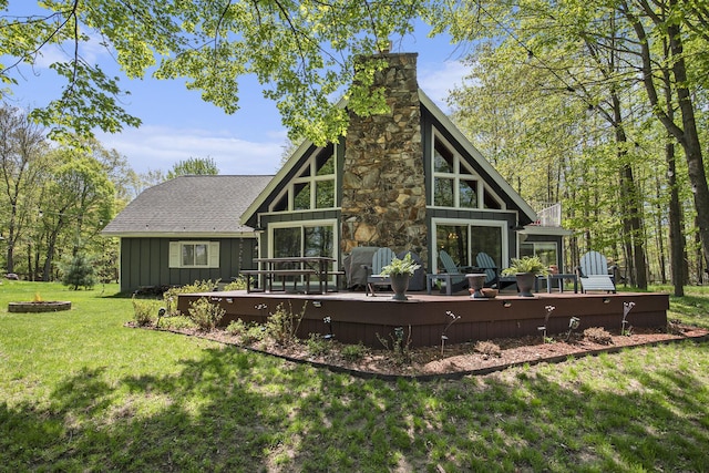 9787 Center Ln, Canadian Lakes, MI 49346 - rear view of house with a chimney, a deck, a lawn, and board and batten siding