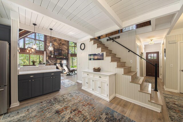 9787 Center Ln, Canadian Lakes, MI 49346 - kitchen featuring hardwood / wood-style floors, freestanding refrigerator, healthy amount of natural light, decorative light fixtures, and wood walls