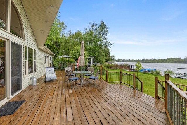 13341 Clausen Rd, Trufant, MI 49347 - wooden terrace featuring outdoor dining area, a water view, and a lawn