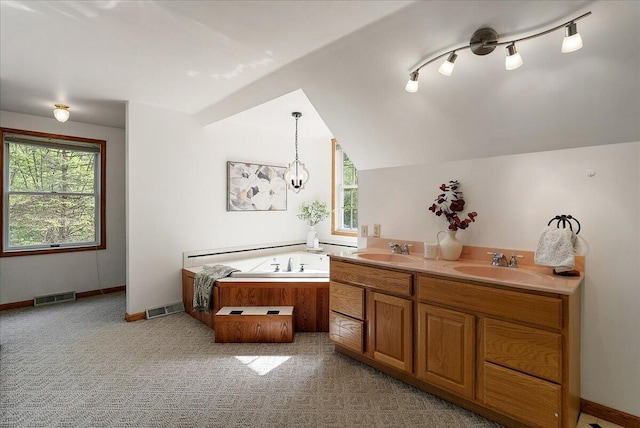 1710 215th Ave, Morley, MI 49336 - bathroom featuring a garden tub, lofted ceiling, double vanity, baseboards, and carpet