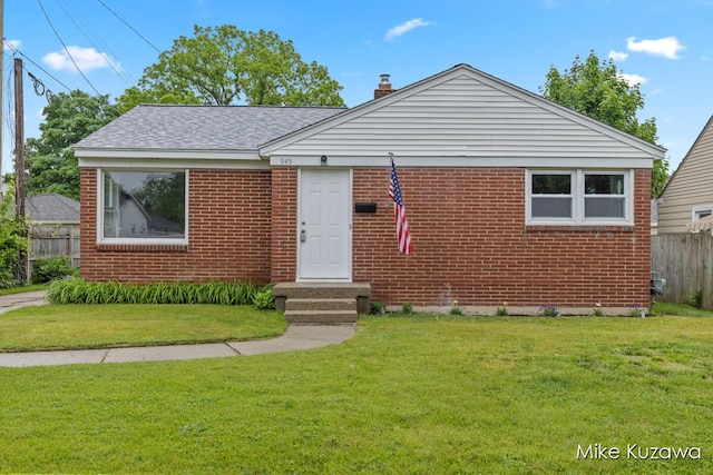 945 NW Dorothy St NW, Grand Rapids, MI 49504 - view of front of home with brick siding, a chimney, and roof with shingles