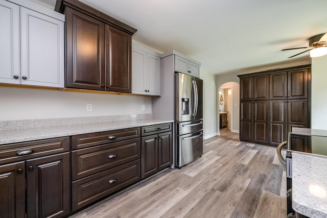 481 Gilson St, Coloma, MI 49038 - kitchen featuring stainless steel fridge with ice dispenser, arched walkways, ceiling fan, light wood-type flooring, and dark brown cabinets
