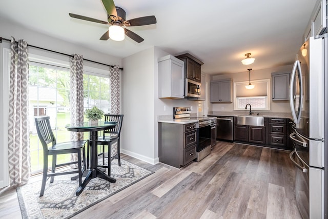 481 Gilson St, Coloma, MI 49038 - kitchen with appliances with stainless steel finishes, a sink, light countertops, a ceiling fan, and light wood finished floors