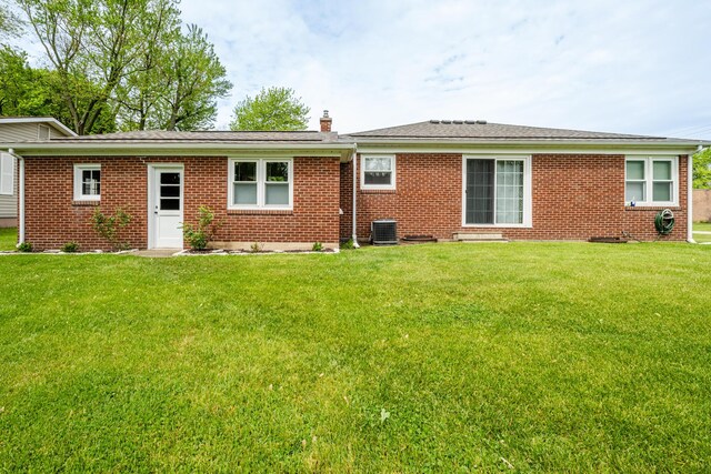 481 Gilson St, Coloma, MI 49038 - rear view of property with central air condition unit, a chimney, a yard, and brick siding