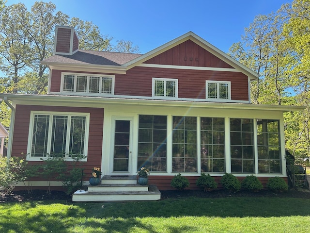 46306 Station Rd, New Buffalo, MI 49117 - view of front of house featuring a chimney, a front yard, and a sunroom