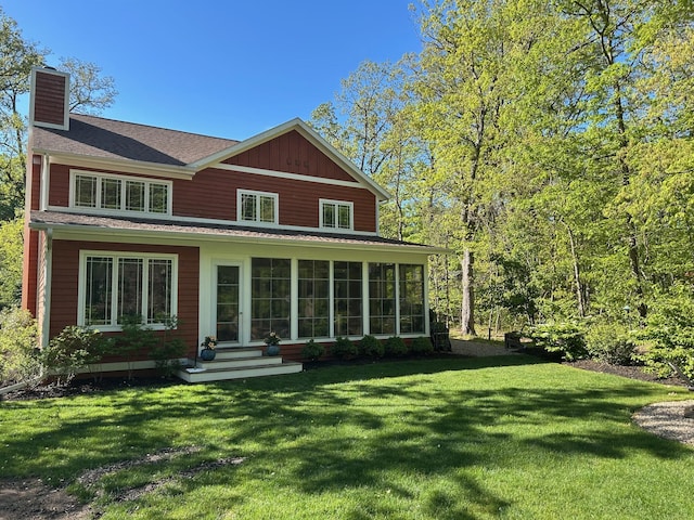 46306 Station Rd, New Buffalo, MI 49117 - view of front of home with a chimney, a front lawn, and a sunroom