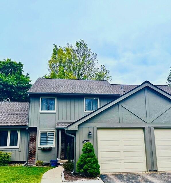 44750 Erin Dr, Plymouth, MI 48170 - view of front of home with board and batten siding, a garage, and a shingled roof