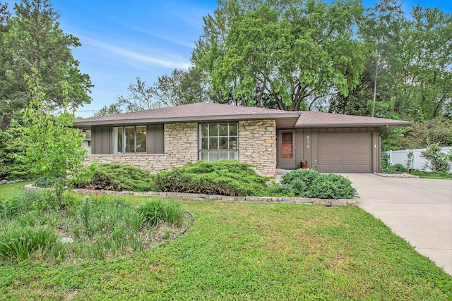 515 Springfield Cir, Niles, MI 49120 - view of front of house with stone siding, an attached garage, concrete driveway, a front lawn, and board and batten siding