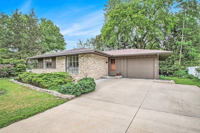 515 Springfield Cir, Niles, MI 49120 - view of front facade featuring a garage, concrete driveway, stone siding, board and batten siding, and a front yard