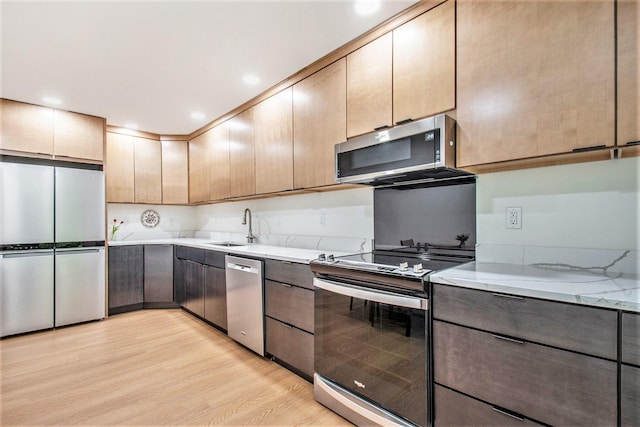 515 Springfield Cir, Niles, MI 49120 - kitchen featuring appliances with stainless steel finishes, light wood finished floors, a sink, and light stone counters