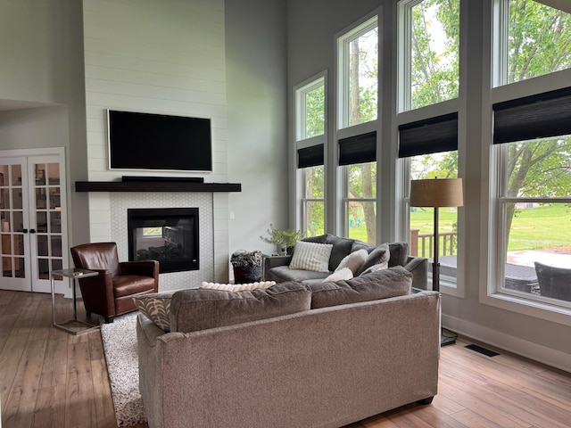 8460 Woodridge Dr, Davison, MI 48423 - living area with hardwood / wood-style flooring, a glass covered fireplace, baseboards, and french doors