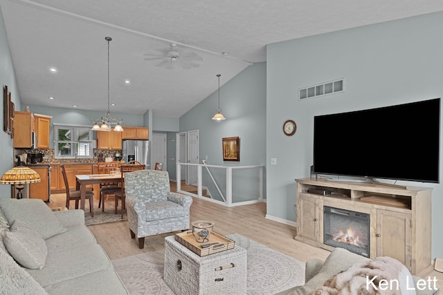 936 Amber View Dr SW Unit 160, Byron Center, MI 49315 - living area with light wood finished floors, vaulted ceiling, ceiling fan, a fireplace, and baseboards