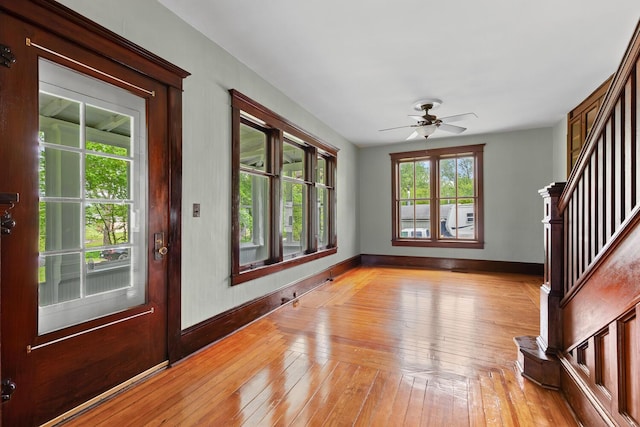 8001 S Jackson Rd, Jackson, MI 49201 - entryway featuring baseboards, light wood-style floors, ceiling fan, and stairs