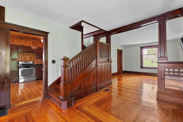 8001 S Jackson Rd, Jackson, MI 49201 - stairway featuring hardwood / wood-style flooring, baseboards, and decorative columns